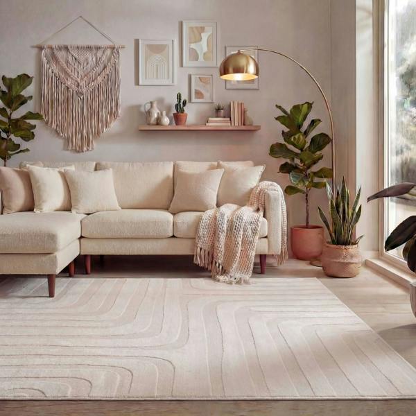 Modern living room with a beige sectional sofa, decorative plants, and wall art.