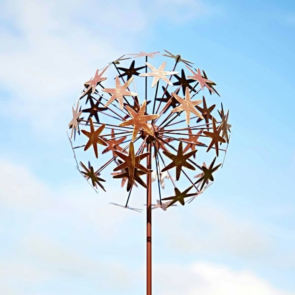 a Metal Allium Flower Garden Stake Decoration against a blue sky.