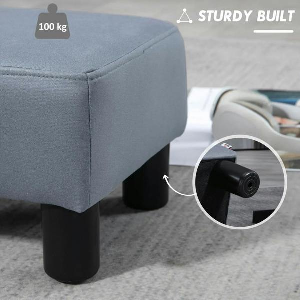 Grey footstool with padded corner and sturdy black legs, side detail