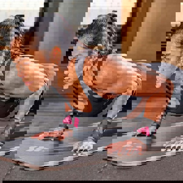 Person doing push-ups on a mat with Adidas wrist straps