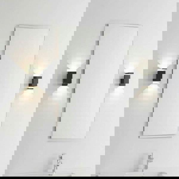 black wall bathroom lamp mounted either side of a mirror in a modern bathroom 