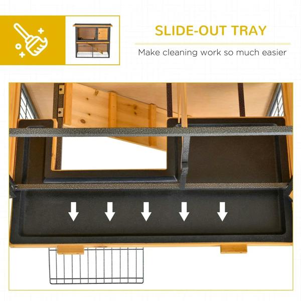 Slide-out tray area on a light yellow rabbit hutch with black metal bars.