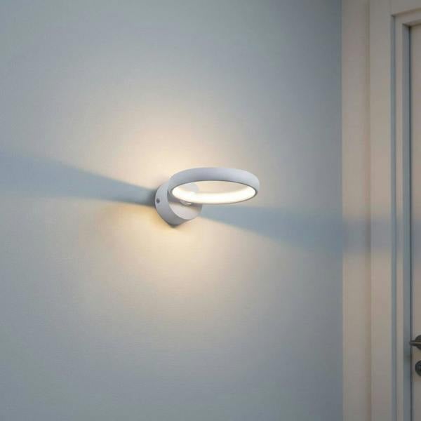 White indoor LED sconce light on a pale blue wall in a hallway
