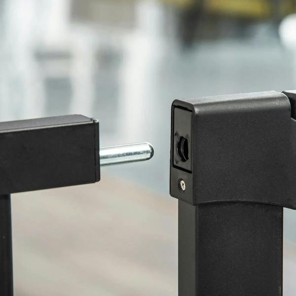 Black pressure-fit pet gate latch and mounting post, close-up detail