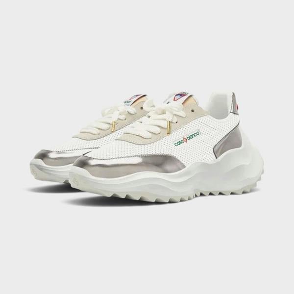 Supplied Fashion Atlantis sneaker in white with chrome metallic accents, featuring a chunky sole and perforated upper.