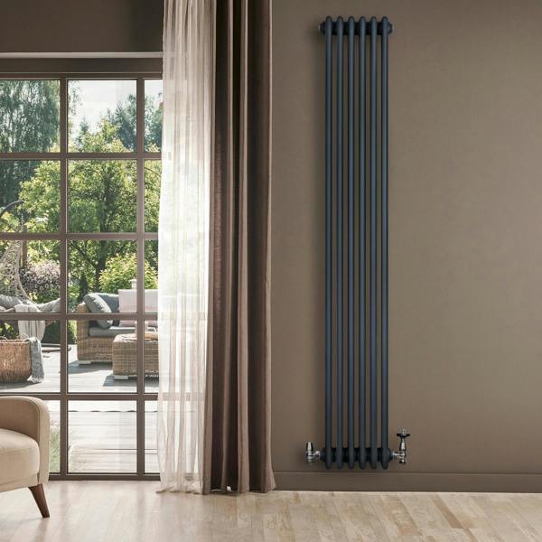 Traditional 4 column radiator in anthracite grey, featuring a sleek vertical design, mounted on a wall beside a large window