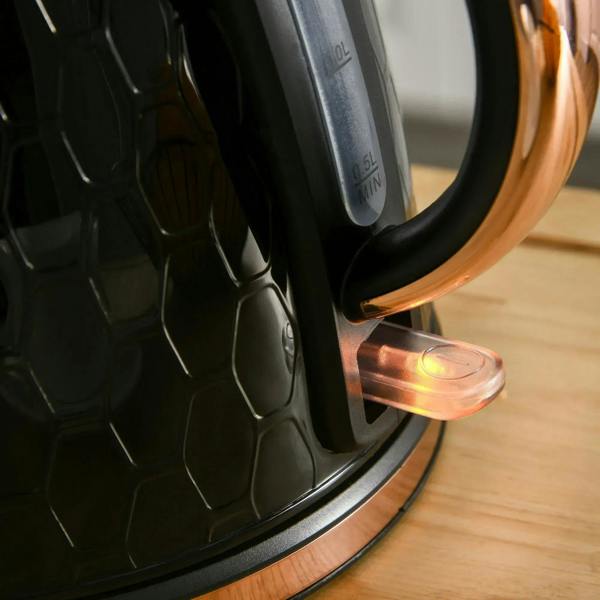 Black electric kettle on base with illuminated power indicator and cord connection