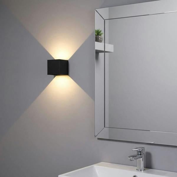 black wall bathroom lamp mounted next to a bathroom mirror