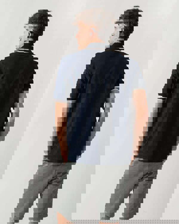 back shot of a model wearing an Aquascutum Mens Stretch Piquet Tipped Badge Polo Shirt in Navy 11