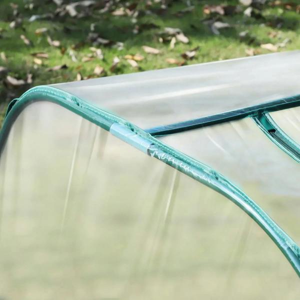 Clear PVC greenhouse cover with green reinforced edge seam and arched frame tube close-up