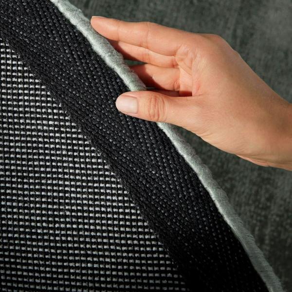 Hand touching a textured fabric surface with a focus on texture and material.