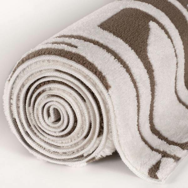 Rolled-up beige and brown patterned rug on a light background