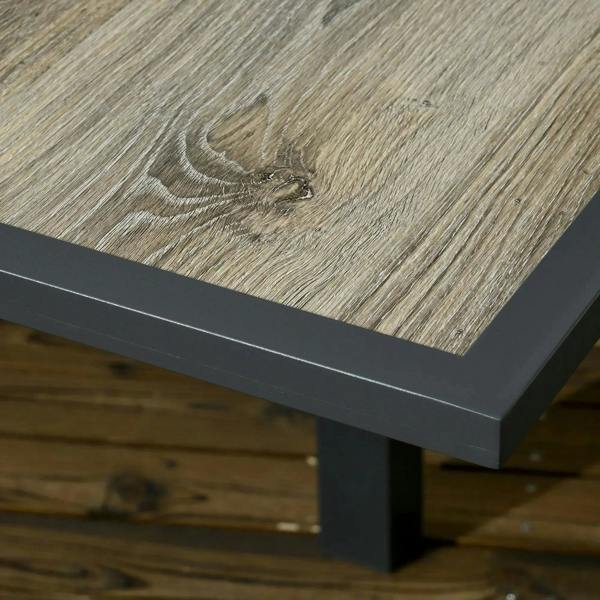 Close-up of grey woodgrain tabletop surface with dark metal edge trim
