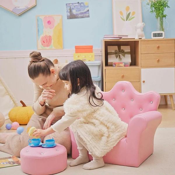 Pink kids armchair with matching round footstool, child playing next to seat