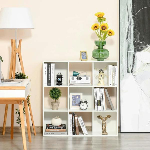 White 9-cube shelving unit with open compartments displaying books, plants, and ornaments