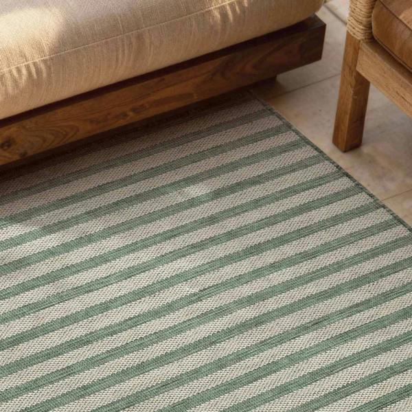 Striped green and beige rug with wooden furniture in the background