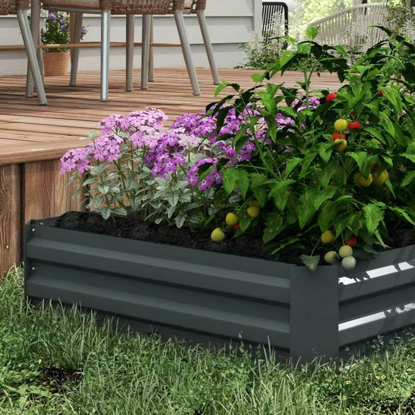 Dark grey raised garden bed planter filled with flowers, herbs, and small fruits