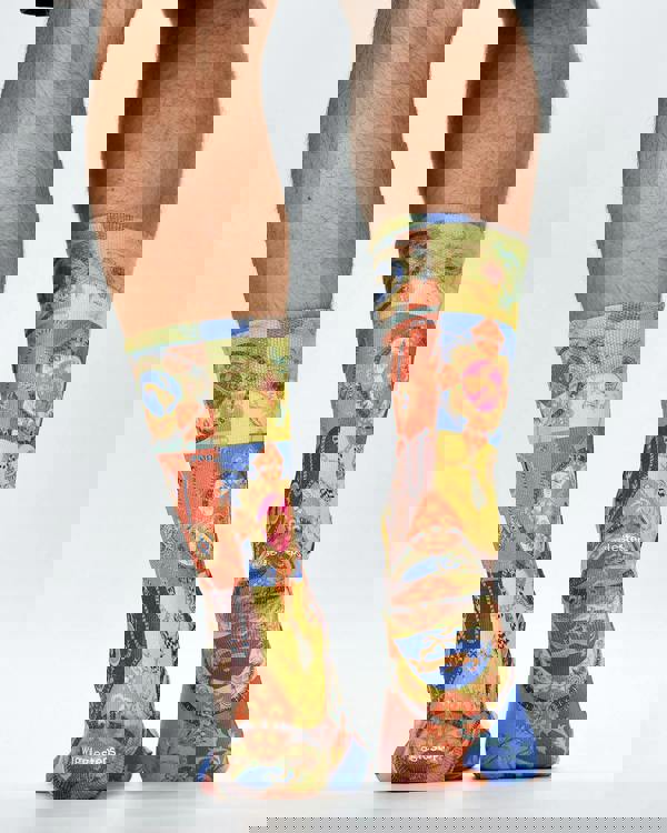 Colorful patterned socks worn by a person on a white background