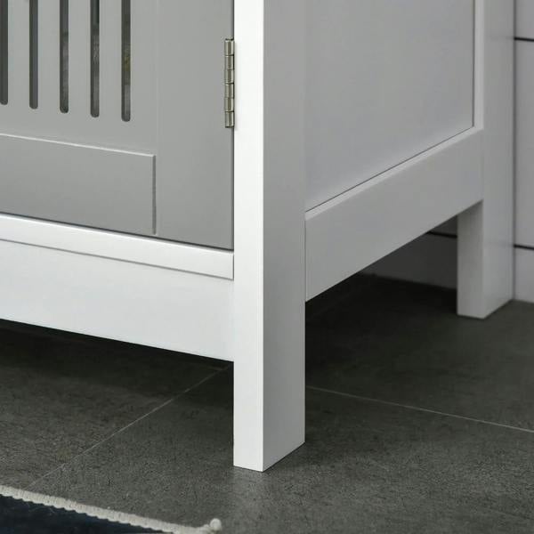 Grey under-sink cabinet corner with slatted door and white raised legs.