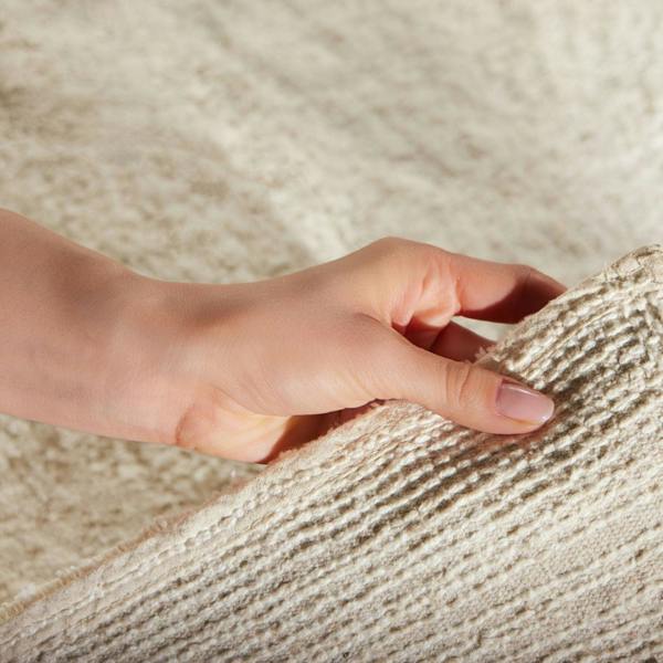 Hand touching textured beige fabric