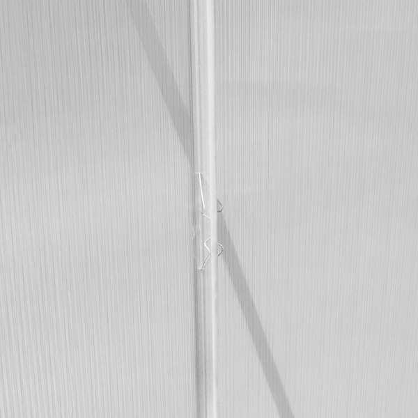 Close-up of the silver polycarbonate panels of a 6ft x 10ft greenhouse, showcasing the textured surface and sturdy construction