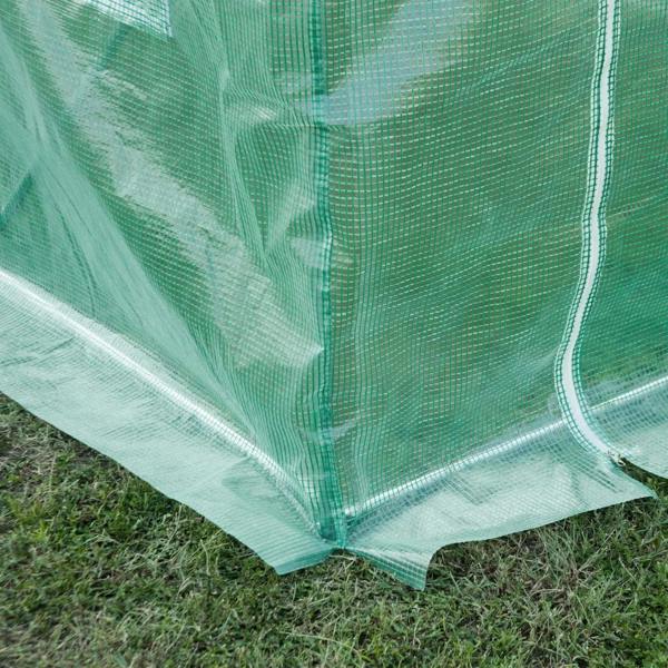 Green greenhouse cover corner with reinforced hem and grommeted edge over ground