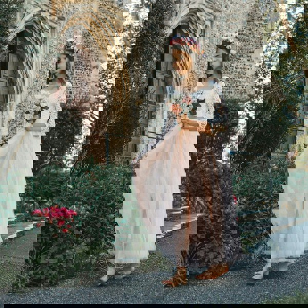Young girl in a floral dress standing in front of a church entrance.