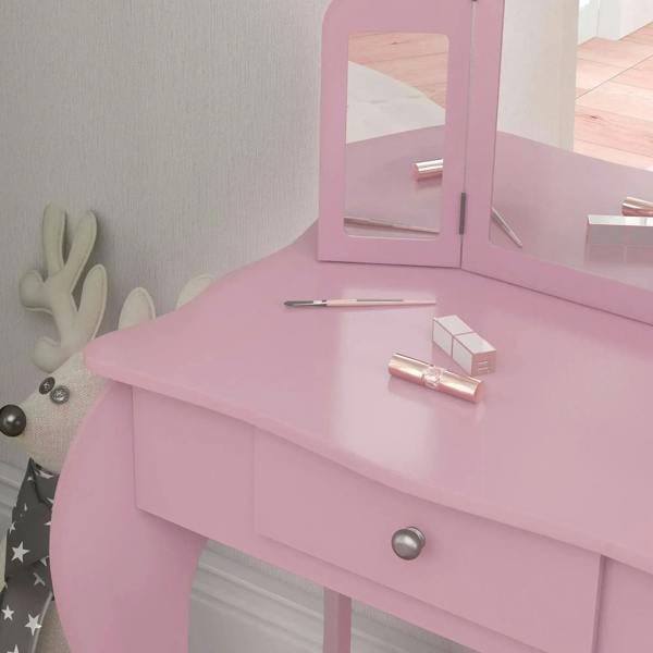 Pink vanity table with tri-fold mirror frame and tabletop makeup items