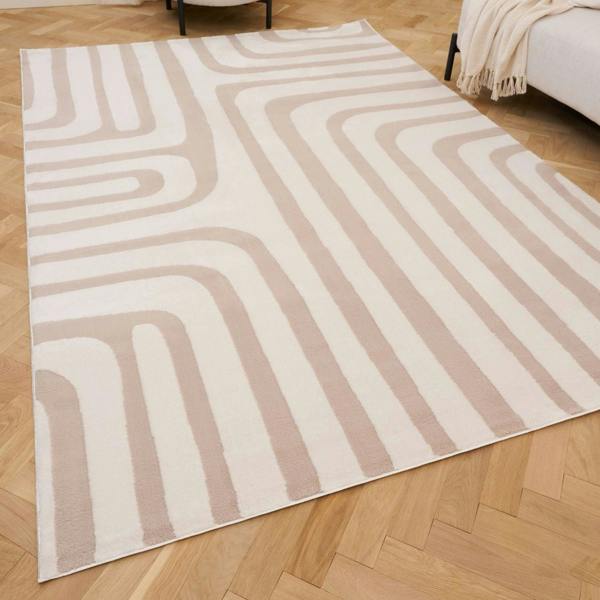 Beige and white geometric patterned rug on a wooden floor
