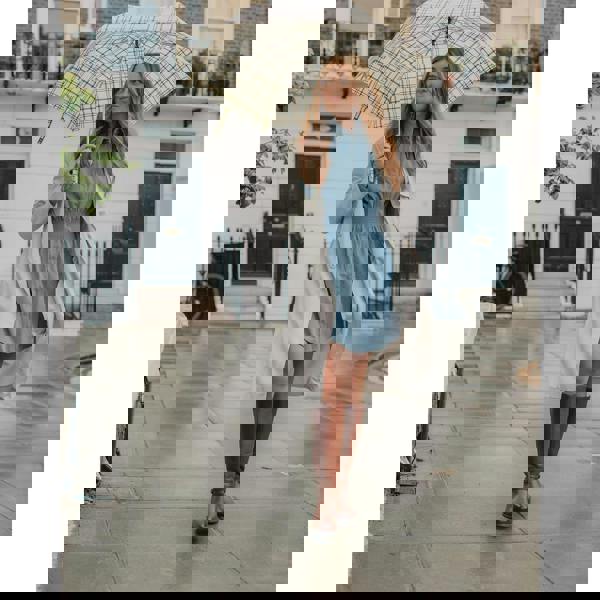 Hush Puppies Women's Vanessa Mid Calf Leather Boots, stylish brown leather boots worn by a woman walking on a rainy city street.