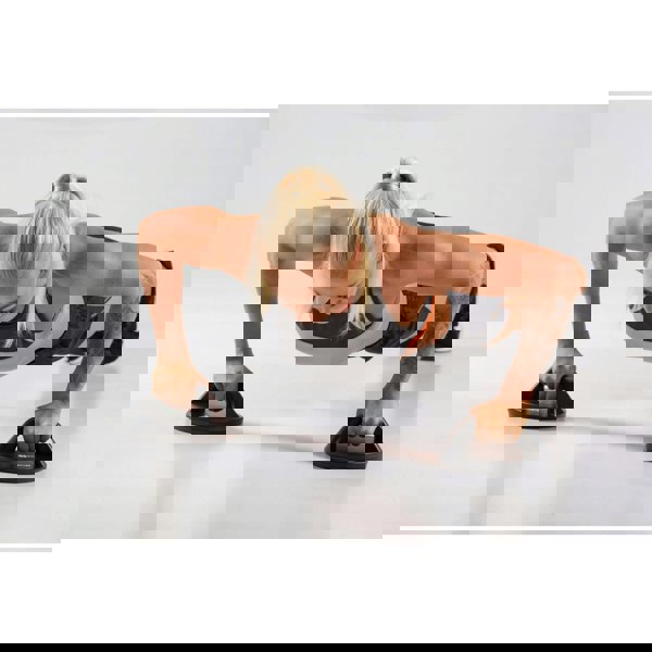 Woman performing push ups using HXGN Rotating Push Up Handles