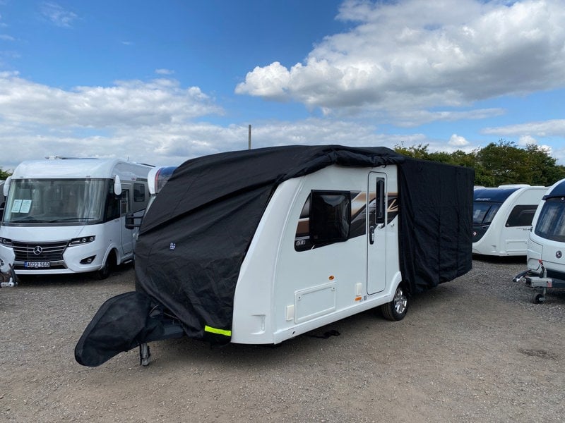 An image of the Breathable Waterproof 4Ply Caravan Cover with Free Hitch Cover Black from OLPRO with the side slightly zipped open.