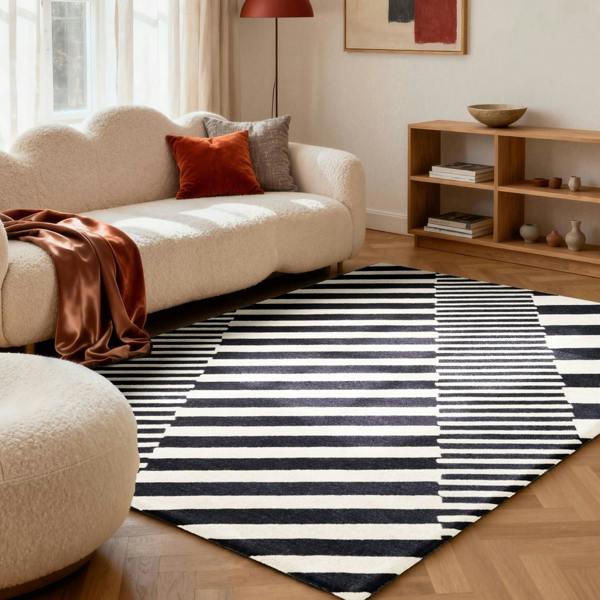 Living room with a striped rug, beige sofa, and wooden shelf.