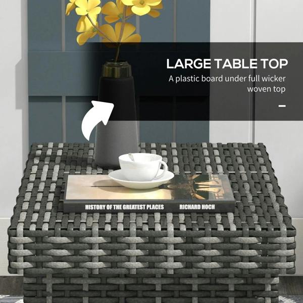 Grey rattan side table with a cup and saucer on the woven tabletop