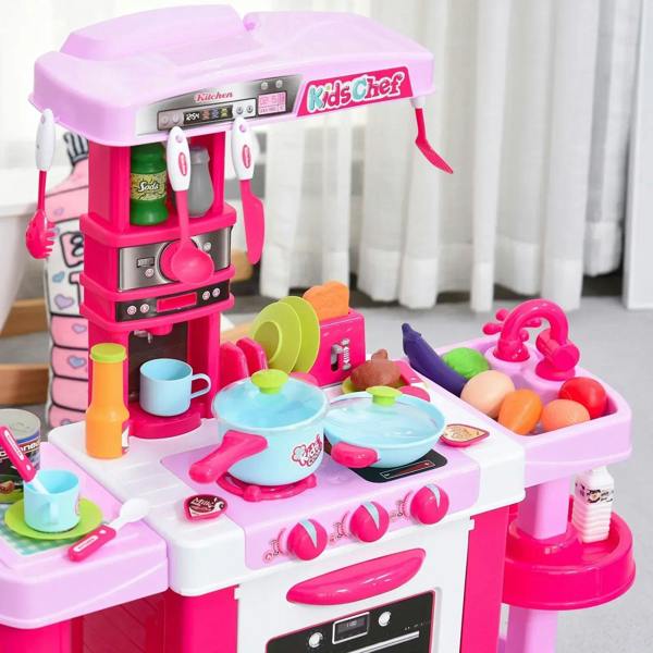 Top view of pink kids kitchen play set with hanging tools and cooking accessories on counter.