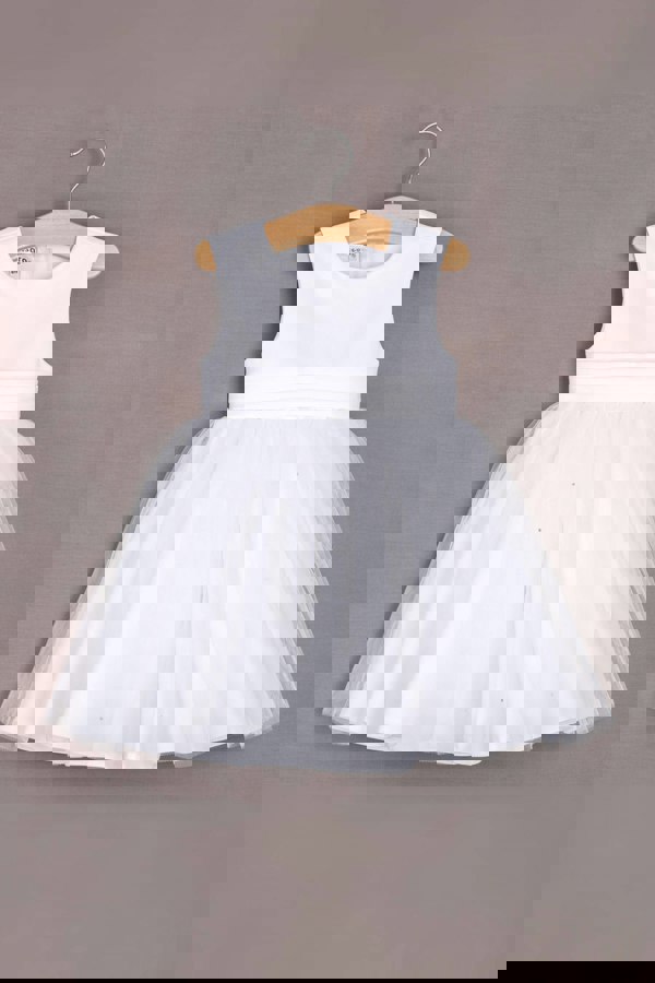 White dress on a wooden hanger against a gray background