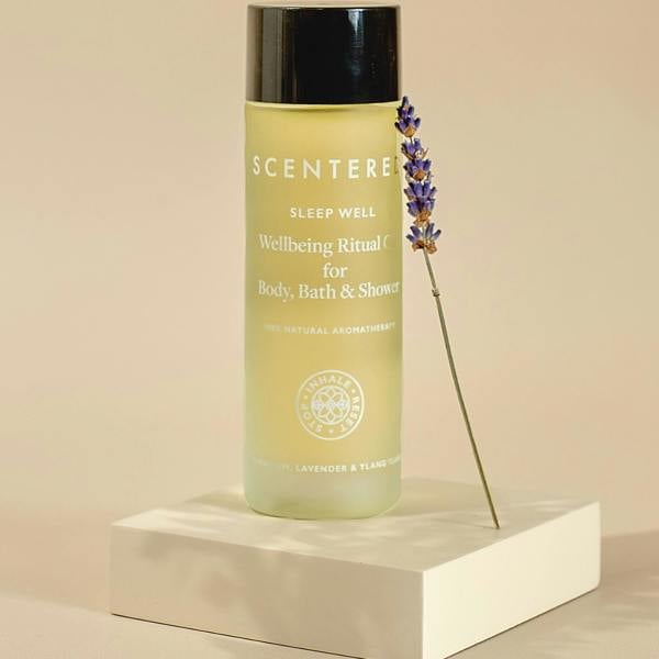 Scentered Sleep Well Body oil in bottle on plinth with lavender on a beige background