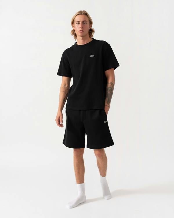 Model wearing the Lacoste Regular Fit Mens Fleece Shorts - Black 031