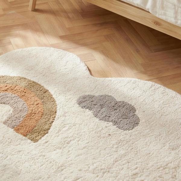Round white rug with rainbow and cloud pattern on a wooden floor