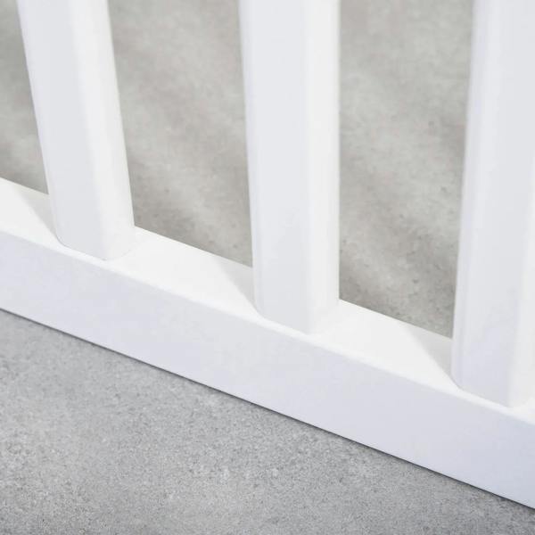White wooden pet gate base with vertical bars and support rail on the floor