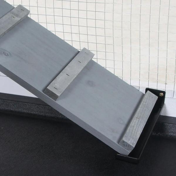 Grey rabbit hutch ramp platform with black textured cover and hinged support