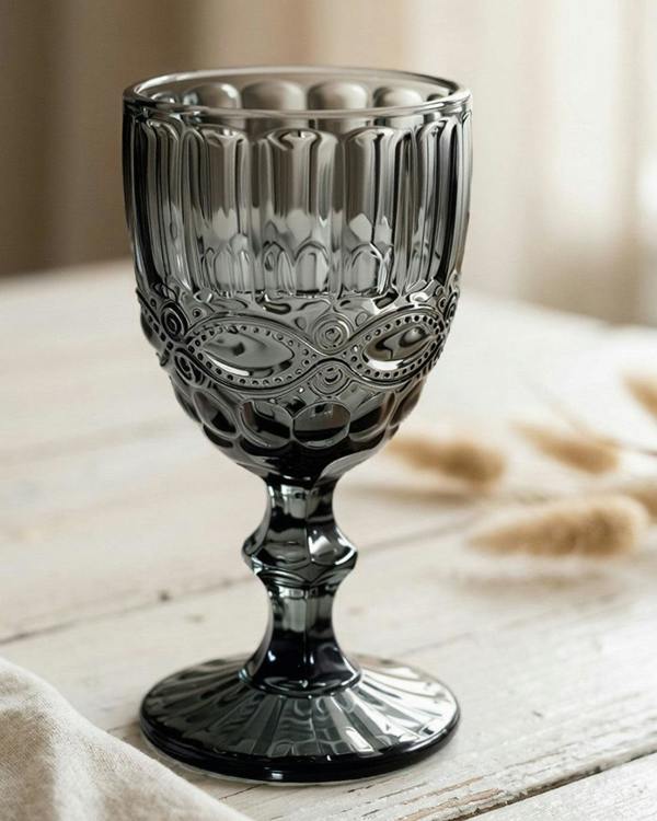 Set of grey glass goblets on a wooden surface with a white background