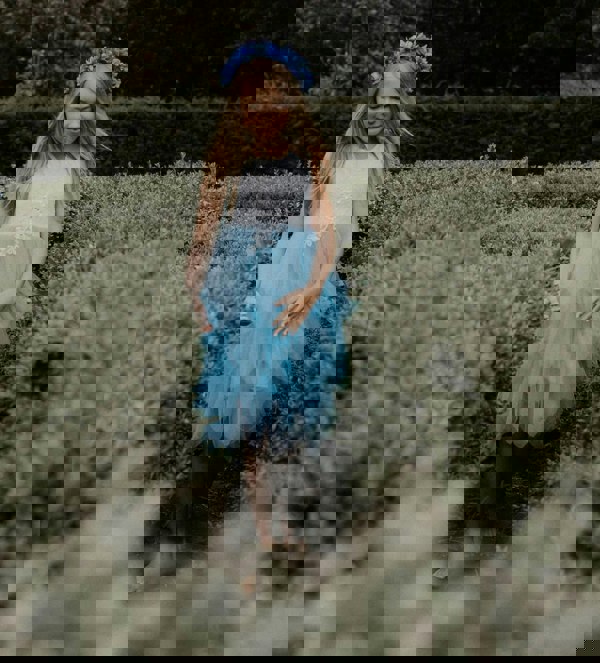 young flower girl walking in field