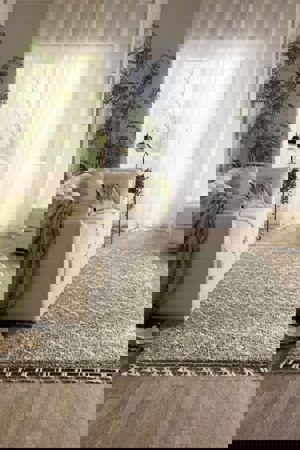 Moroccan style rug in Eucalyptus Green color placed in a modern living room with soft lighting and cozy furniture.