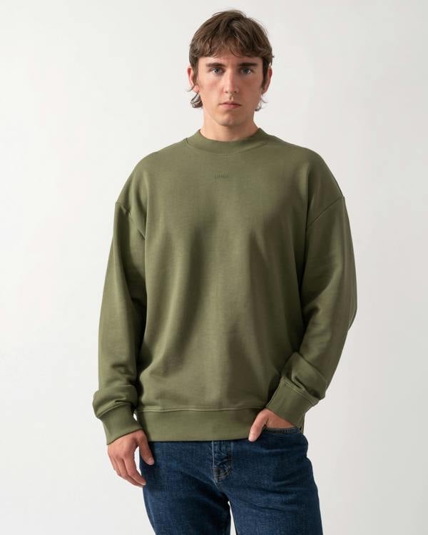 model wearing a HUGO Dapocrew Mens Crew Neck Sweatshirt in Open Green 388