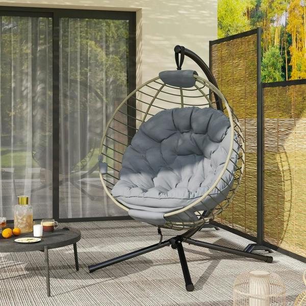 Grey hanging rattan swing chair with quilted cushion and black metal tripod stand