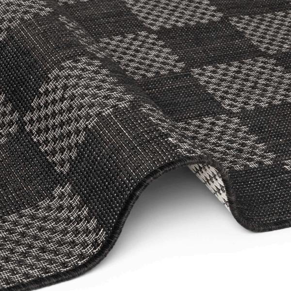 Close-up of a textured black and gray checkered fabric with a white background