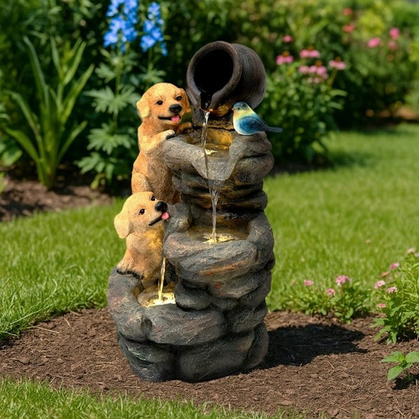 Electric water feature featuring two playful golden retriever puppies beside a cascading fountain with a bird, set in a garden