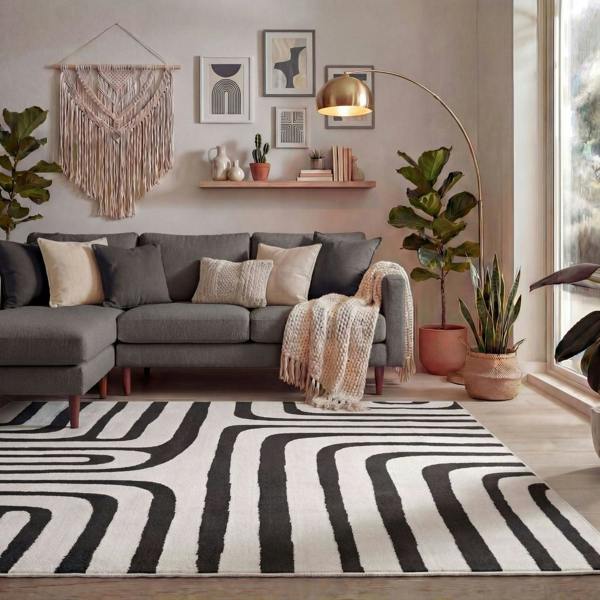 Living room with a gray sectional sofa, patterned rug, and decorative elements.