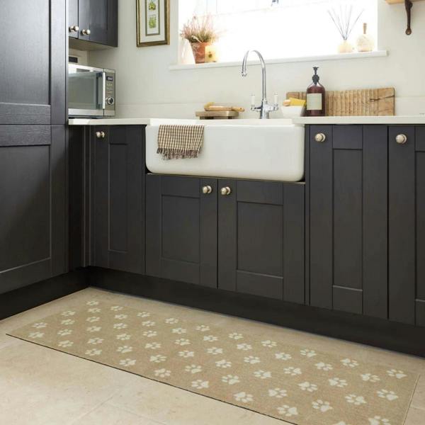 Modern kitchen with dark gray cabinets, white sink, and a patterned rug on the floor.